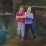 Two young girls by a pond